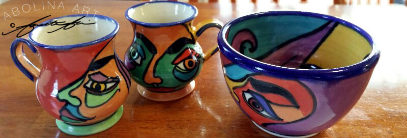 Stoneware mugs and bowl with bright colourful faces