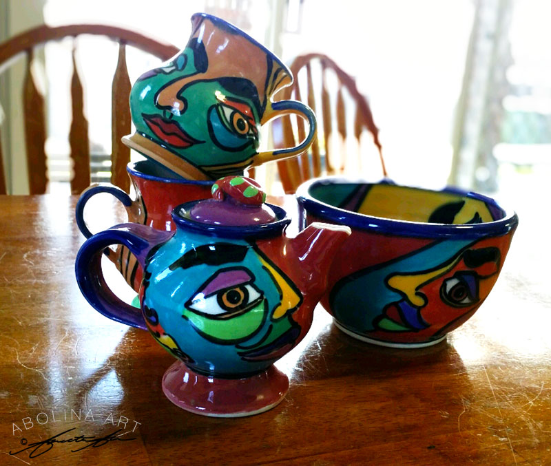 Teapot, mugs and a bowl from 'Faces' range