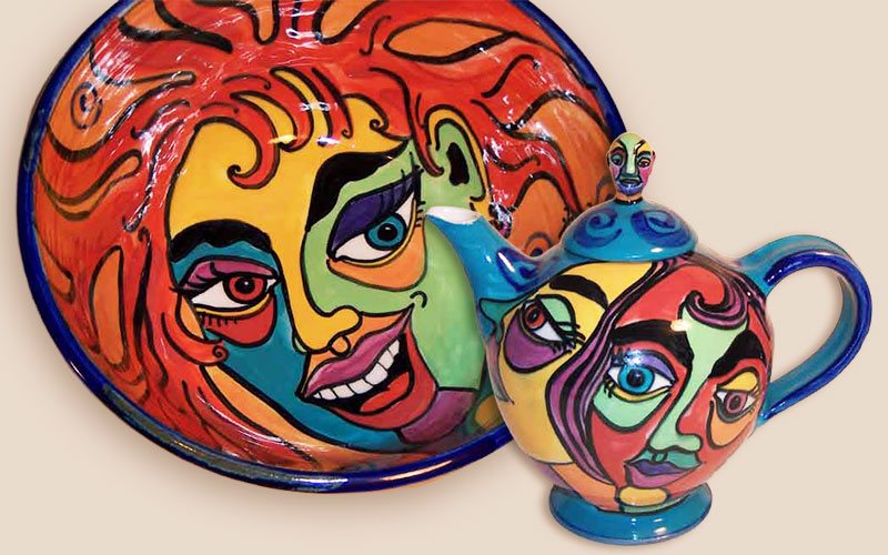 Wheel-formed ceramics bowl and teapot featuring bright colourful faces